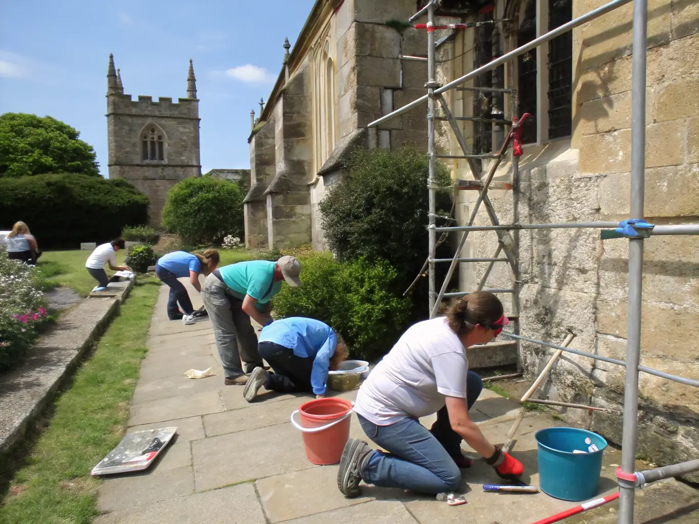 A photograph capturing a group of volunteers from LUMIERE ANTIQUE working on the restoration of a historical building, showcasing their dedication to preserving local heritage.